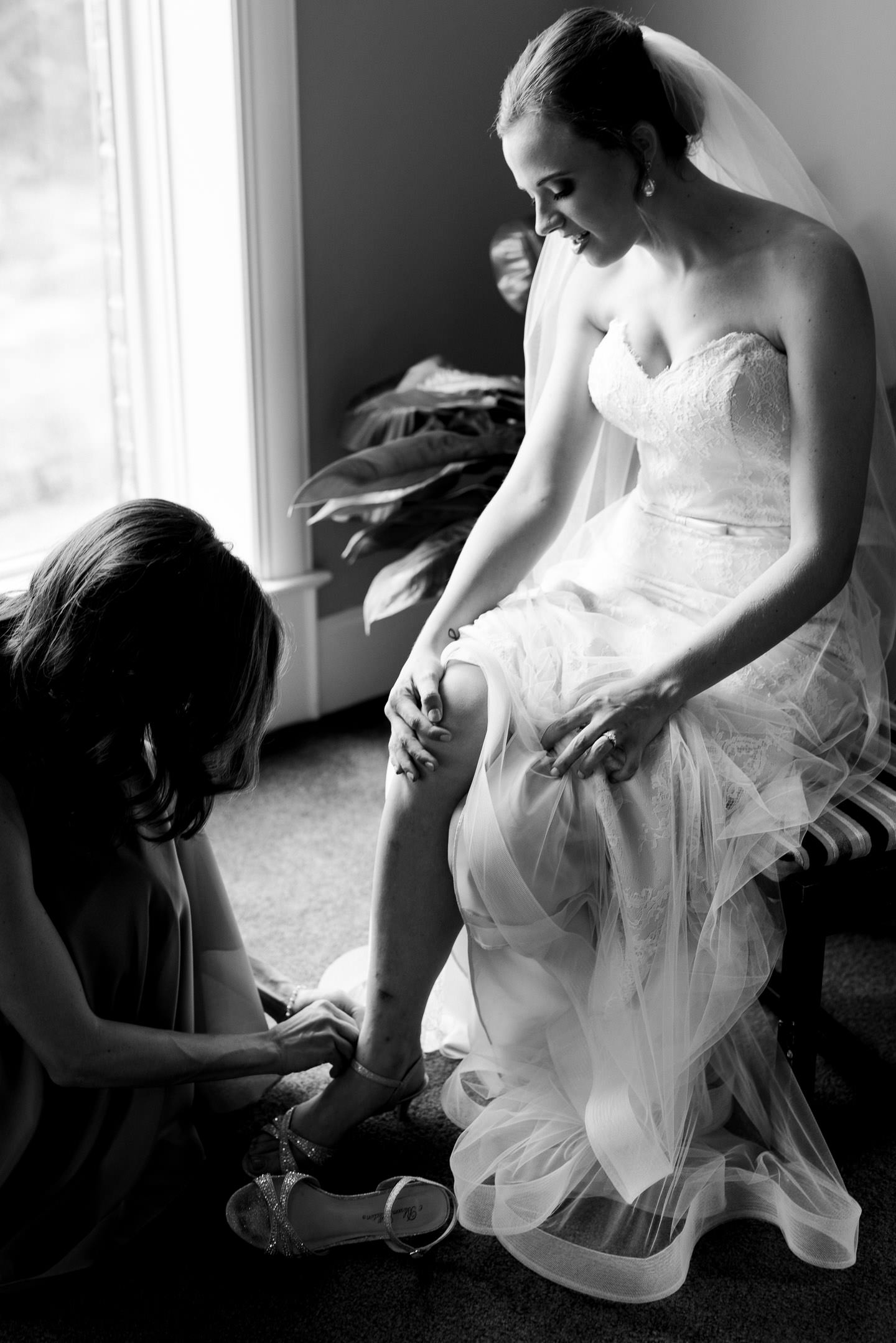 Bride's sister puts on her shoes on her wedding day 