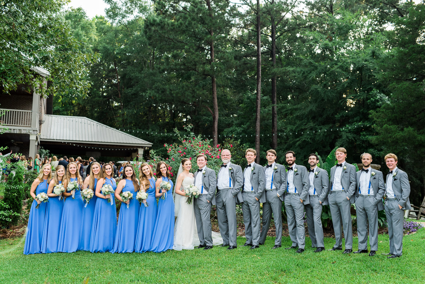 Bride, Bridesmaids, Groom, and Groomsmen smile for a fun portrait following Mississippi wedding ceremony