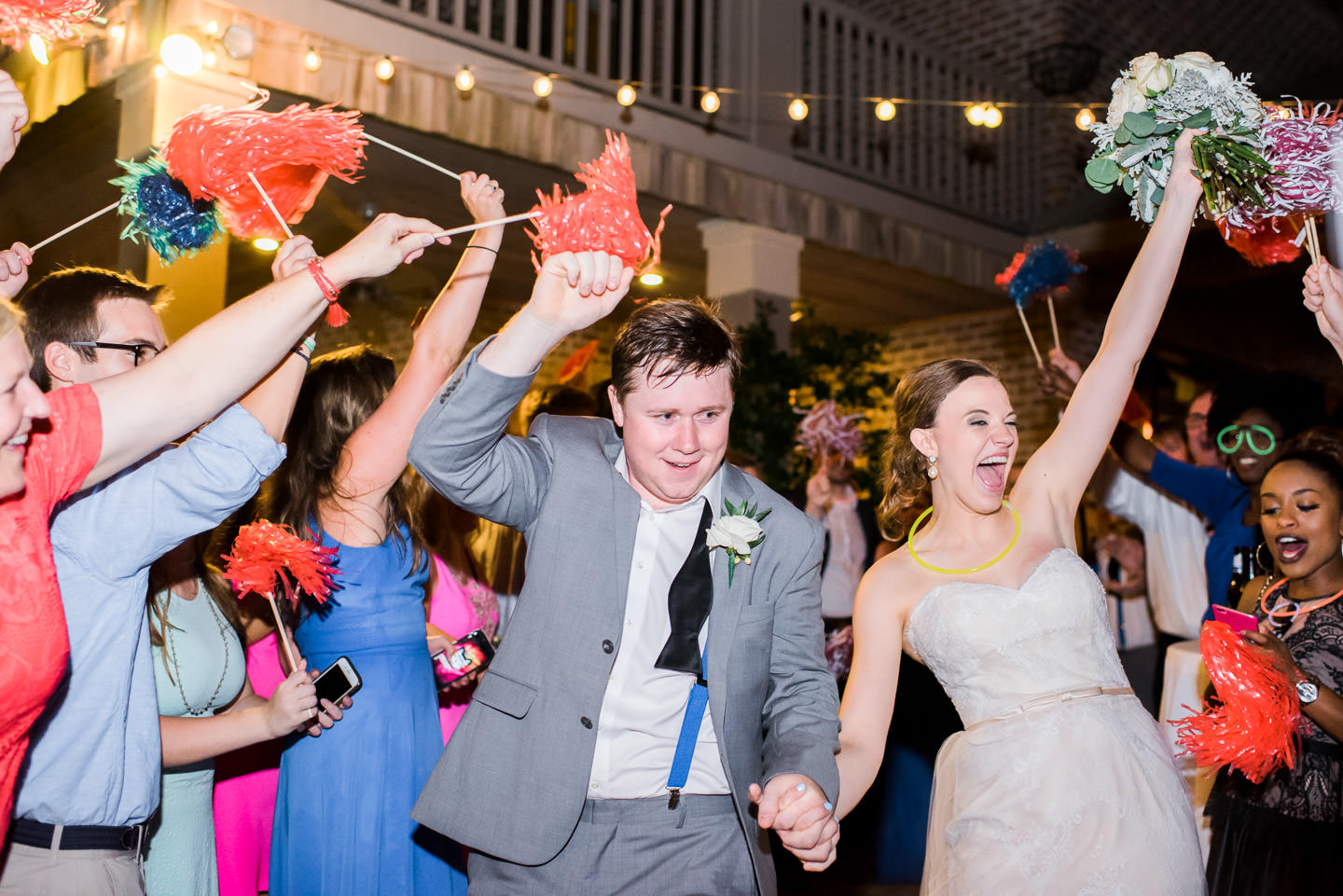 Bride and groom's Jackson, Mississippi wedding reception exit to Ole Miss and Mississippi State pom poms