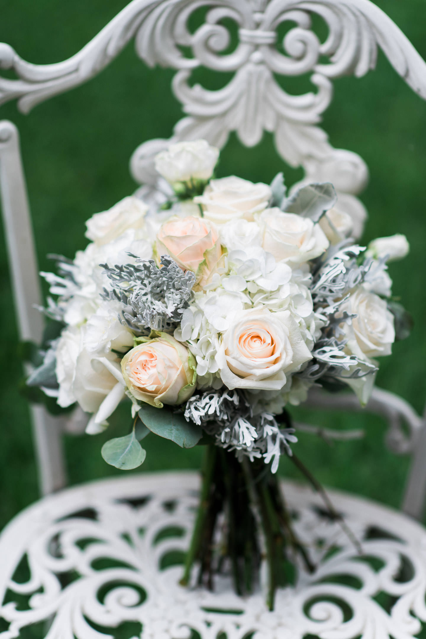 Dusty Miller, peach rose, hydrangea, and eucalyptus bouquet on white iron chair for Mississippi wedding