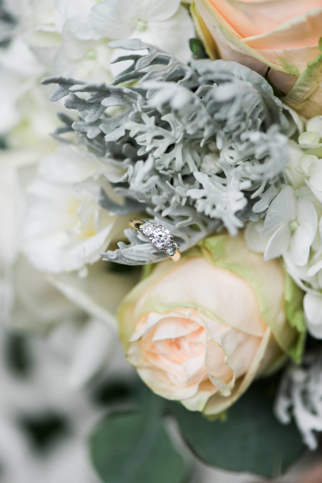 Bride's engagement ring on her floral bouquet